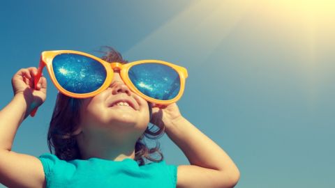 une petite fille avec des lunettes bleues