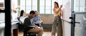 une femme forme ses collègues en petit groupe