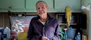 un vieux monsieur pose face caméra