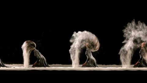 Une femme plonge ses cheveux dans le sable