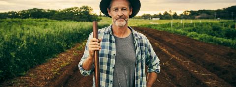 Les start-up veulent révolutionner l'agriculture avec le big data Un agriculteur portant un chapeau et une chemise à carreau, tenant une fourche, dans un champ