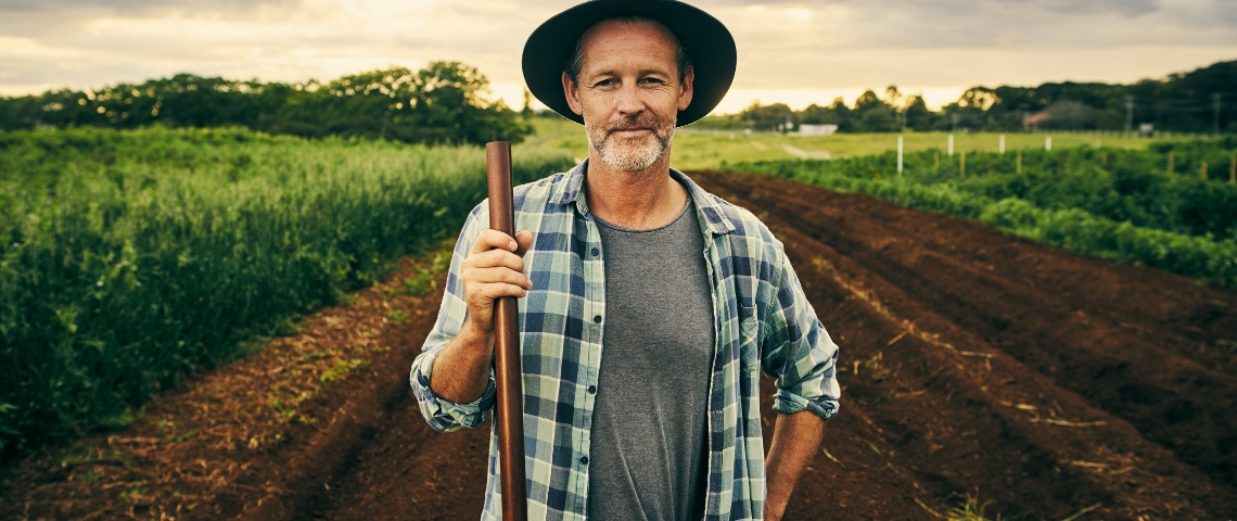 Les start-up veulent révolutionner l'agriculture avec le big data Un agriculteur portant un chapeau et une chemise à carreau, tenant une fourche, dans un champ