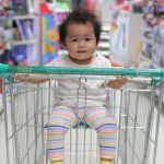 Une petite fille brune au milieu d'un supermarché