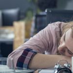 une jeune femme assoupie au travail