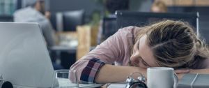 une jeune femme assoupie au travail