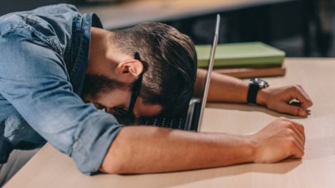 Un homme effondré sur son ordinateur portable