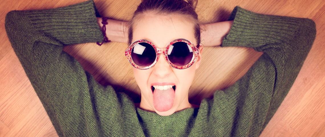 Comment rédiger la biographie Instagram parfaite ? Une femme avec des lunettes de soleil qui tire la langue