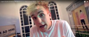 un youtubeur blond dans sa maison fait la promo d'une arnaque