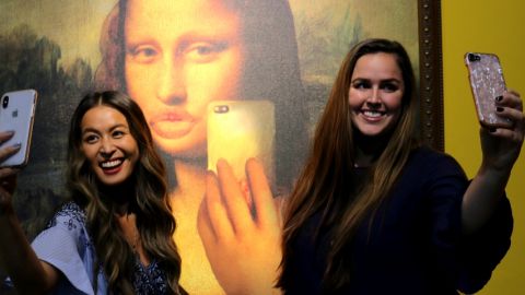 deux filles se prennent en selfie devant la Joconde