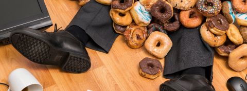 Mal s'alimenter au travail nuit à la productivité Un homme enseveli par des donuts