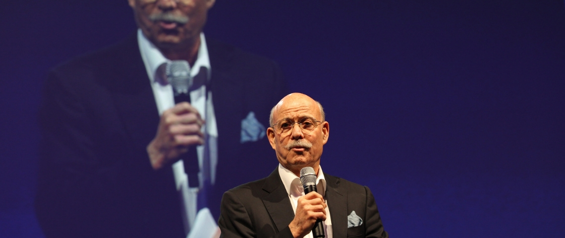 Jeremy Rifkin présente son projet de troisième révolution industrielle Jeremy Rifkin en train de parler au micro avec un écran géant en arrière plan