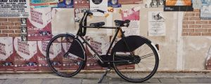 Un vélo noir devant un mur d'affichage