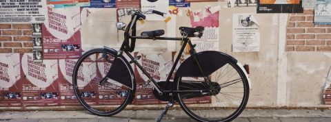 rse ecologie agence Un vélo noir devant un mur d'affichage