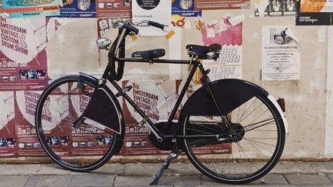 rse ecologie agence Un vélo noir devant un mur d'affichage