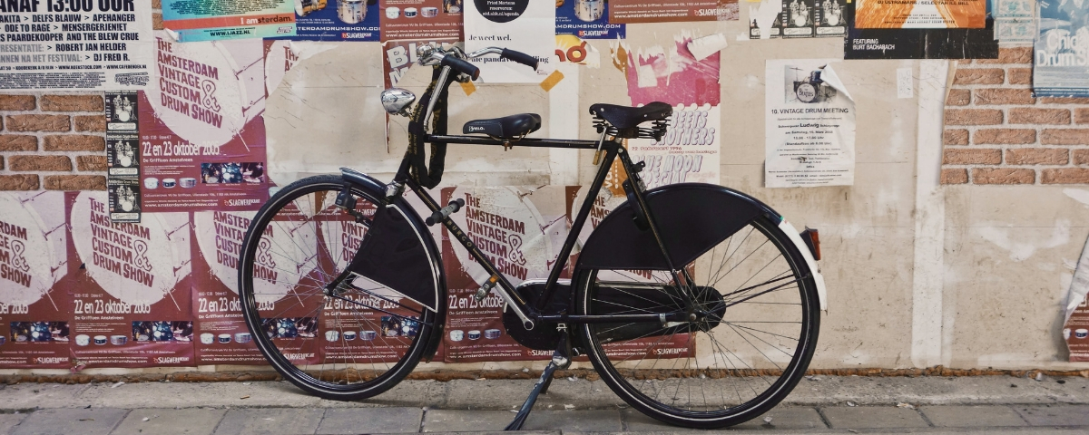 rse ecologie agence Un vélo noir devant un mur d'affichage