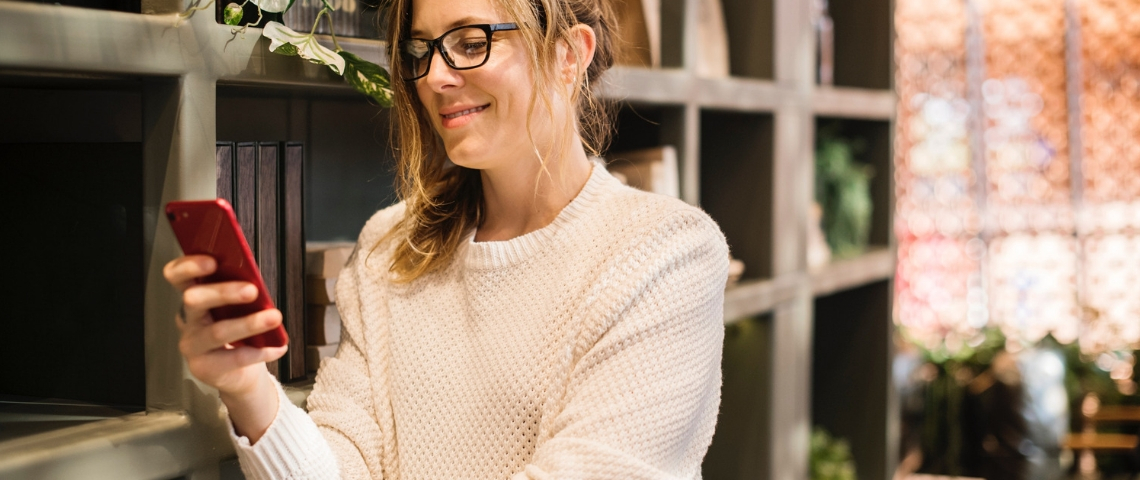 Whatsapp lance son assistant vocal Une femme qui regarde son smartphone