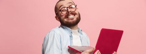 technologie jugaad un homme souriant travaille sur son ordinateur rouge