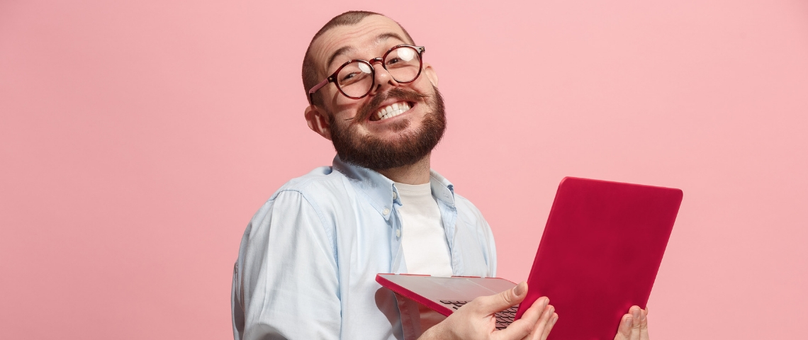 technologie jugaad un homme souriant travaille sur son ordinateur rouge