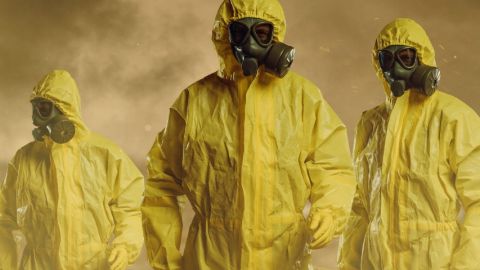 Trois exterminateurs dans des combinaisons jaunes, avec de la fumée