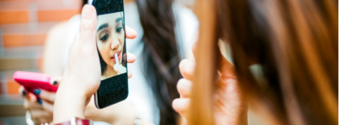 jeune fille qui se maquille devant son écran jeune fille qui se maquille devant son écran
