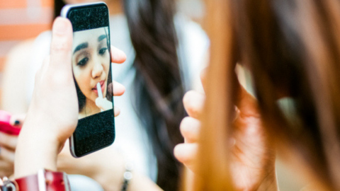 jeune fille qui se maquille devant son écran