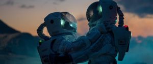 Deux personnes en combinaison d'astronaute qui se font un câlin