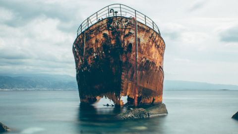 un bateau rouillé échoué sur une plage