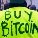 un gilet jaune avec l'inscrpition buy bitcoin
