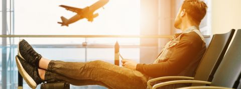 un homme regarde un avion s'envoler dans un aéroport
