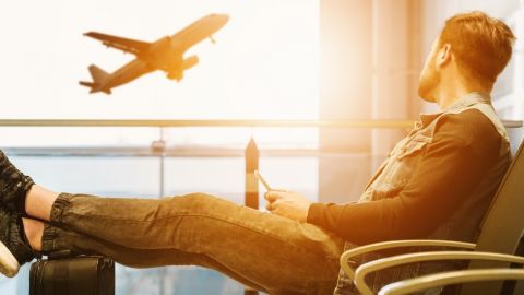 un homme regarde un avion s'envoler dans un aéroport