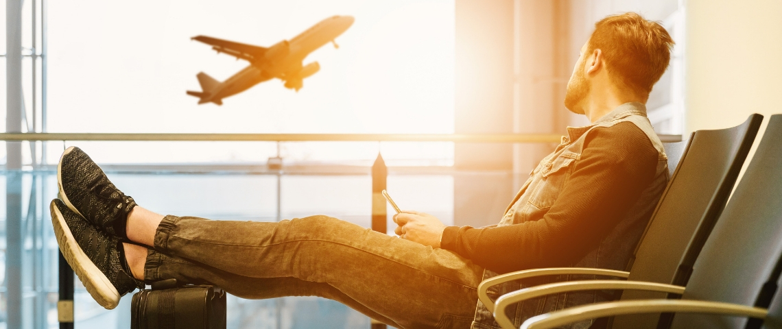 un homme regarde un avion s'envoler dans un aéroport