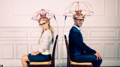 Un homme et une femme dos à dos assis sur une chaise avec un casque sur la tête