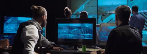 La cyberguerre est à nos portes Des hommes dans une piece sombre qui regardent des écrans