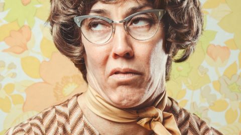 femme à lunettes ringarde sur fond papier peint