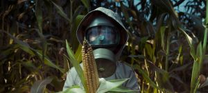 Personne en masque à gaz portant un maïs