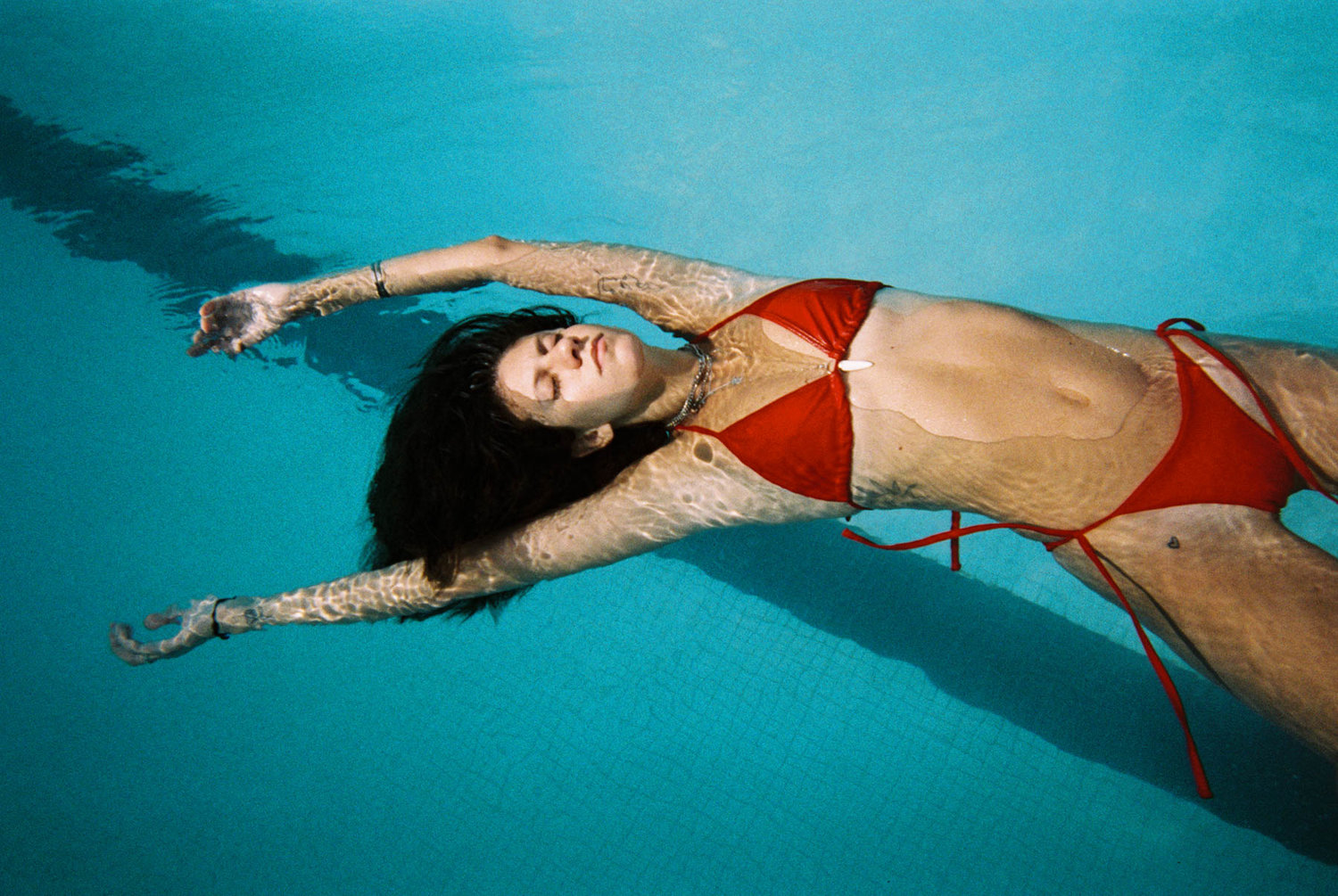 une fille en maillot allongée dans une piscine