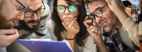 Un groupe de jeunes employés dubitatifs face à un document mystère