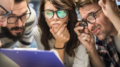 Un groupe de jeunes employés dubitatifs face à un document mystère