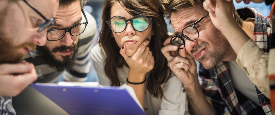 Un groupe de jeunes employés dubitatifs face à un document mystère