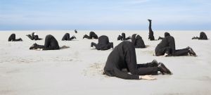 hommes la tête dans le sable