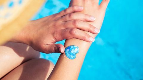 Une femme en train de s'appliquer de la crème solaire au-dessus d'une piscine