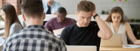 un journaliste se prend la tête dans une newsroom