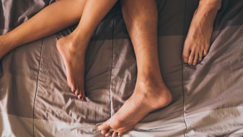 Les pieds d'un couple dans un lit