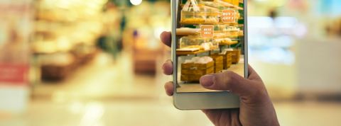 Pourquoi les marques devraient plus miser sur la réalité augmentée Une femme en train de faire ses courses avec son smartphone pour avoir des offres grâce à la réalité augmentée