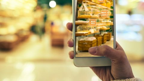 Pourquoi les marques devraient plus miser sur la réalité augmentée Une femme en train de faire ses courses avec son smartphone pour avoir des offres grâce à la réalité augmentée
