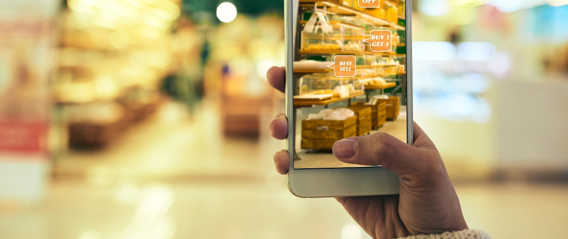 Pourquoi les marques devraient plus miser sur la réalité augmentée Une femme en train de faire ses courses avec son smartphone pour avoir des offres grâce à la réalité augmentée