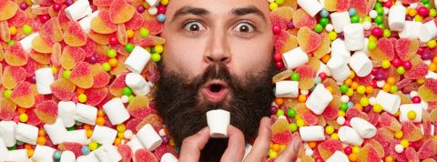 un homme barbu sur fond de bonbons