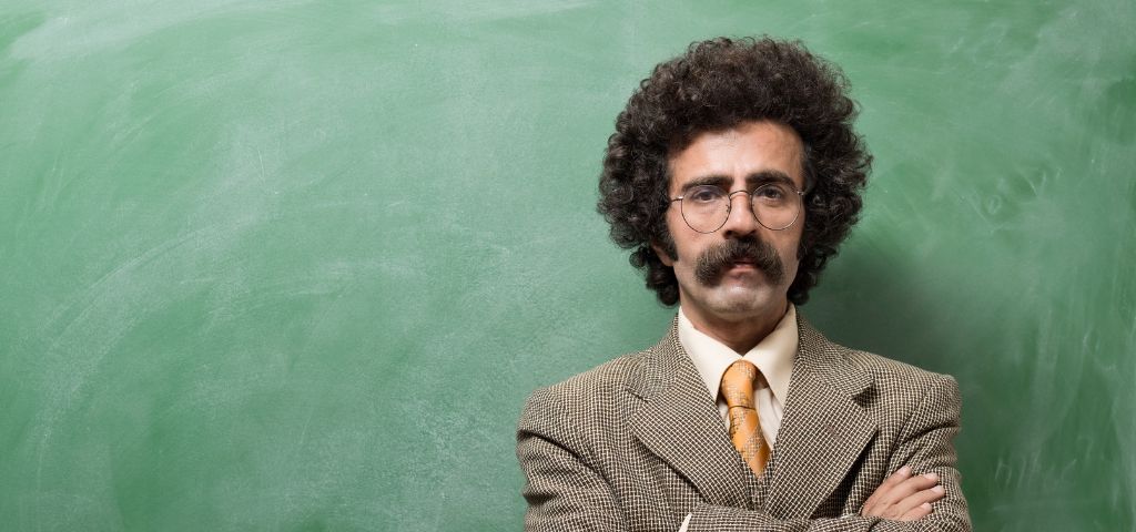 Un instituteur devant un tableau de salle de classe ardoise