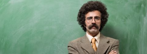 Un instituteur devant un tableau de salle de classe ardoise