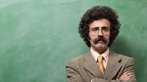 Un instituteur devant un tableau de salle de classe ardoise